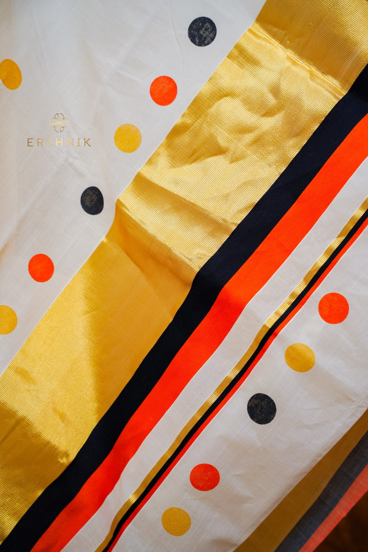 Erthnik™ Balaramapuram Off-white pure cotton handloom saree featuring multicolour polka dots, accented with orange and black kara, and golden kasavu border